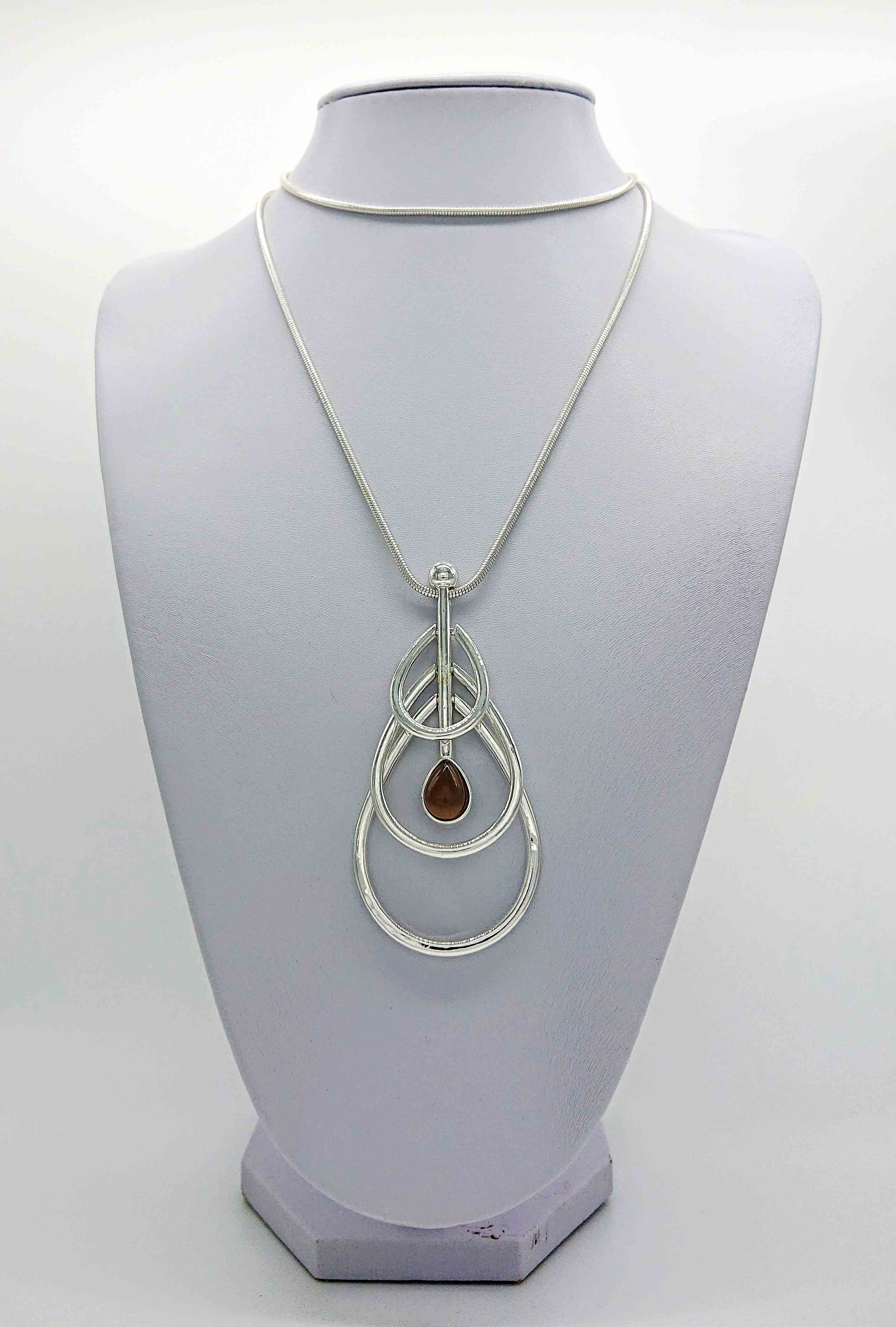 Famile Necklace Longer length silver box chain necklace with a three tiered pendant. A drop pendant with a single dark opal stone effect feature. This beautiful long necklace is a statement piece that can be worn when casual as well as more formal wear Nickel free, silver coloured mixed metal